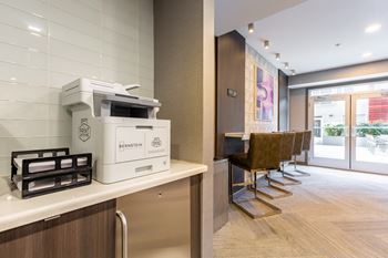 A white bernstein coffee maker is on a counter in a modern office.